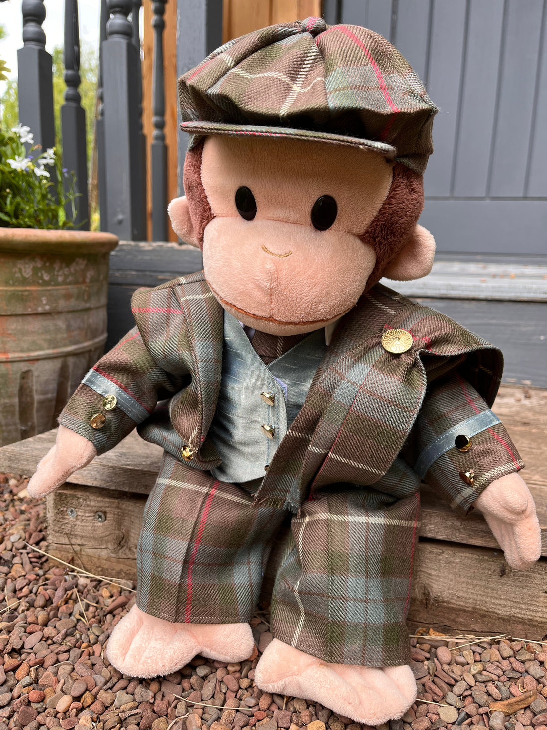 A toy monkey wearing a tartan three-piece suit and hat